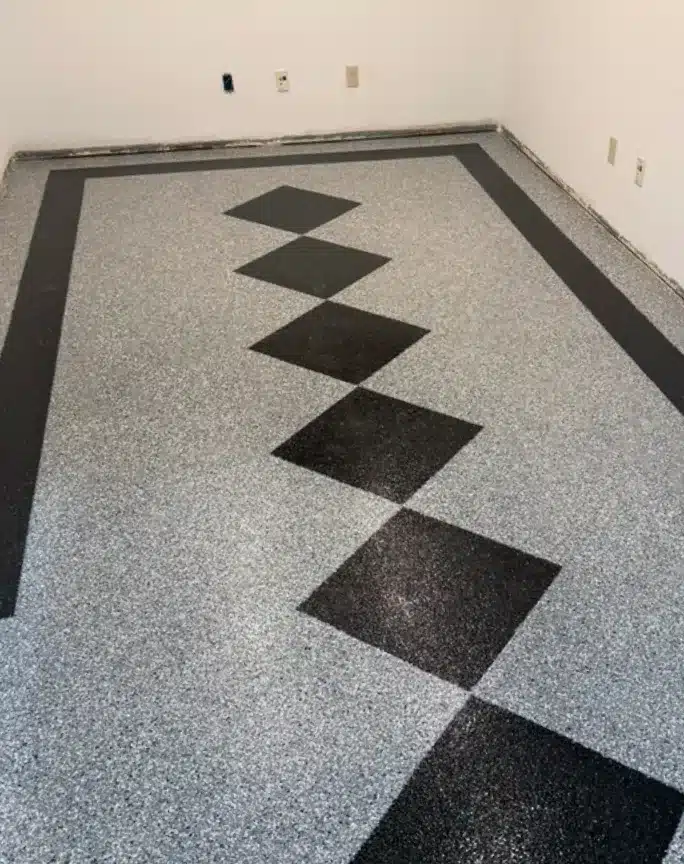 Gray epoxy garage floor with black diamond accents and border design