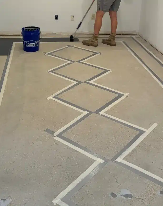 Concrete garage floor with taped geometric pattern before epoxy coating installation