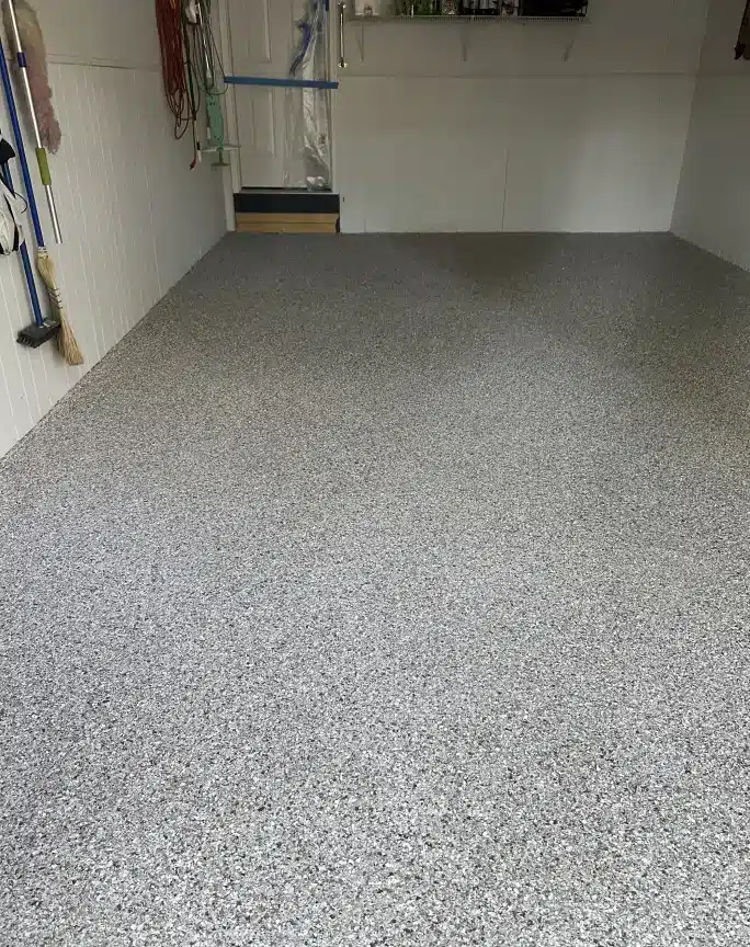 Gray epoxy garage floor with decorative flake finish in a finished residential garage