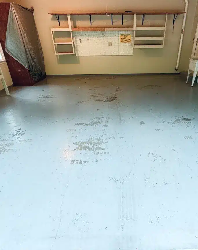 Worn garage floor with stains and tire marks before epoxy coating installation