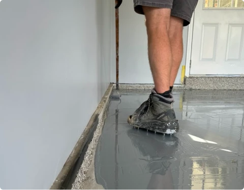 Installer walking on freshly applied gray epoxy garage floor coating