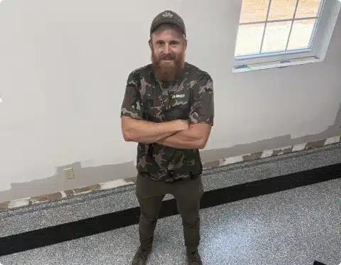 Man standing on a gray epoxy garage floor with black accent striping