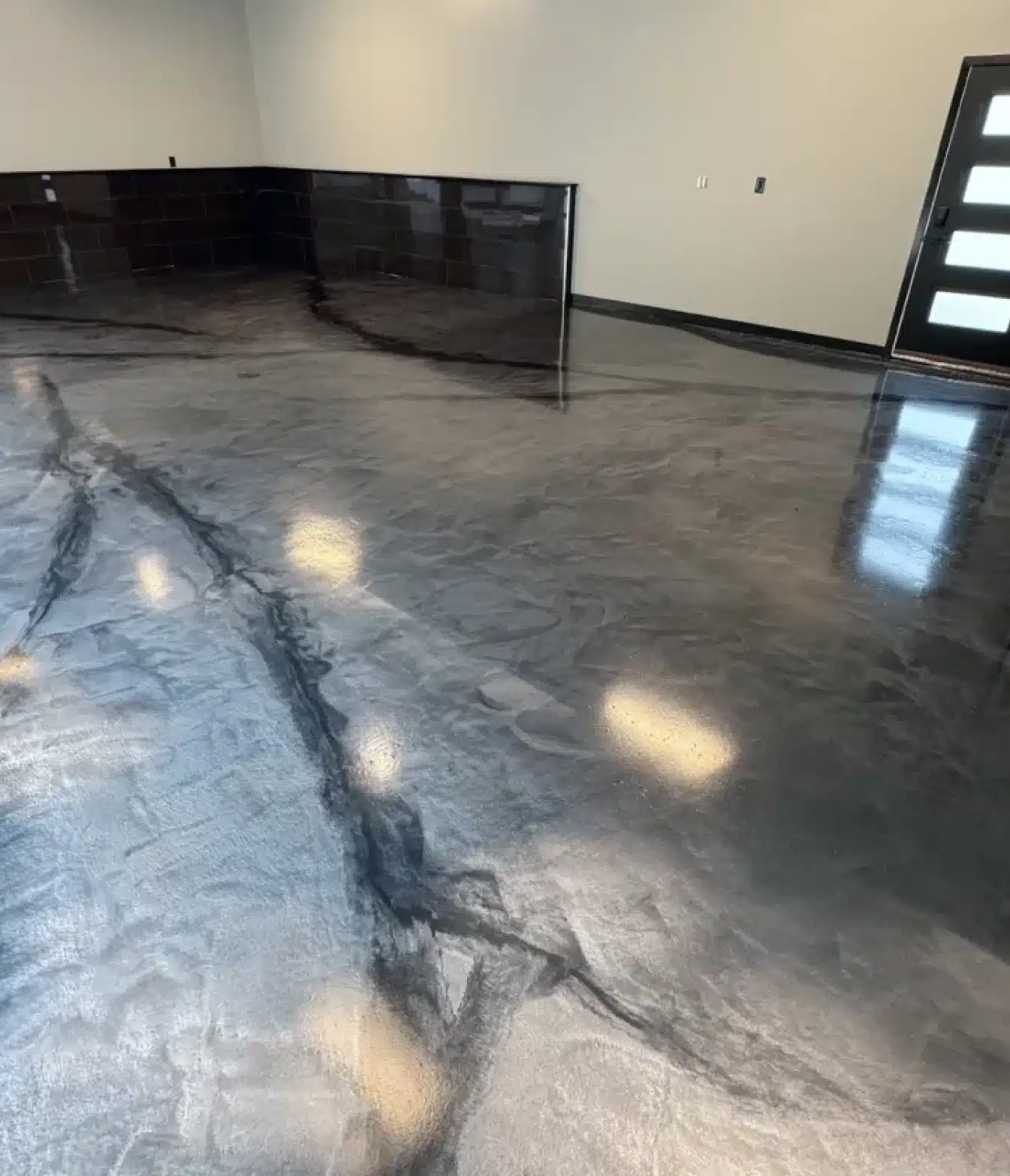 Metallic gray epoxy floor with black marble-style veining in a finished garage