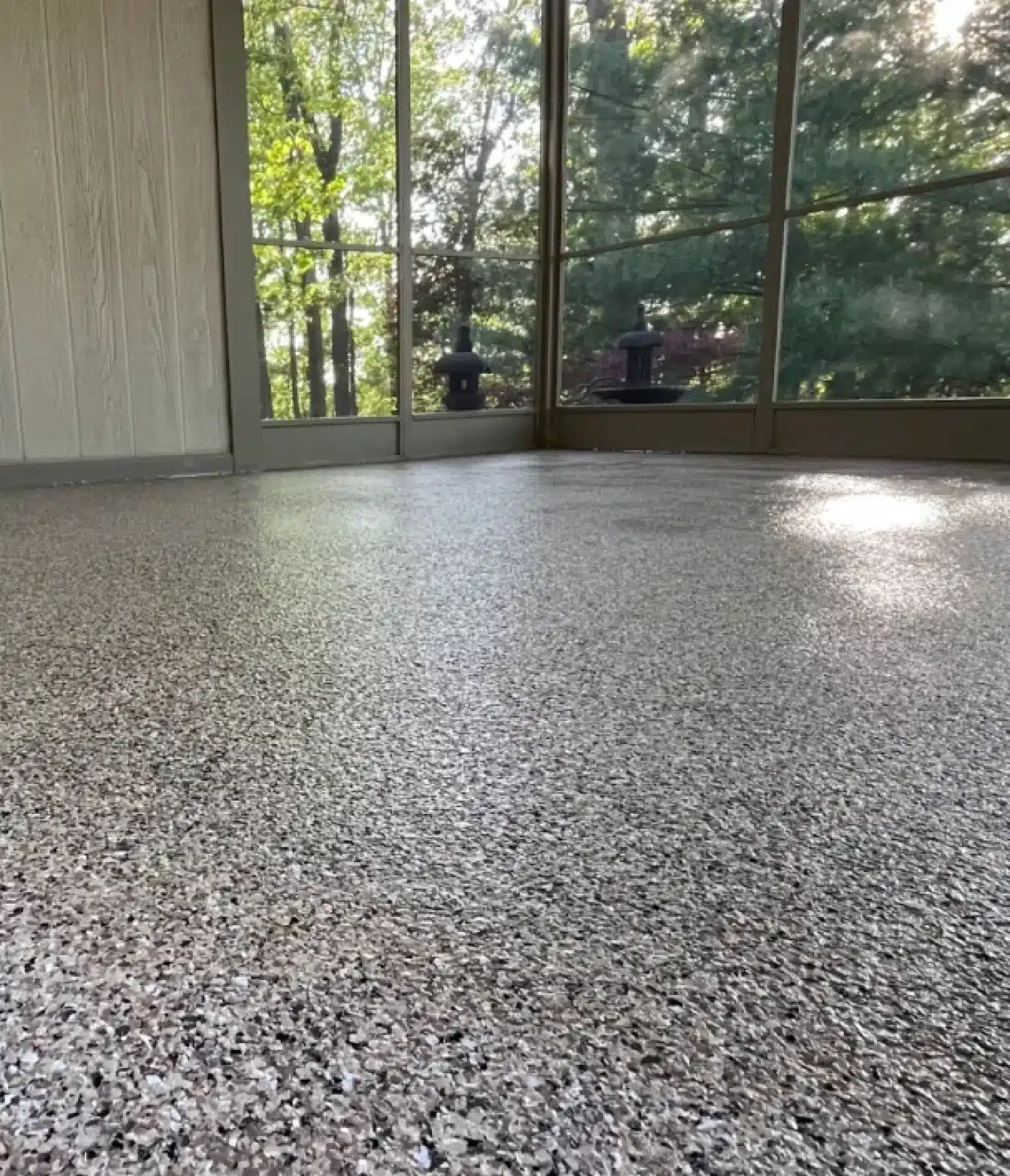 Decorative gray epoxy flake floor in a screened porch or sunroom