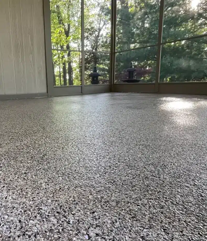 Decorative gray epoxy flake floor in a screened porch or sunroom