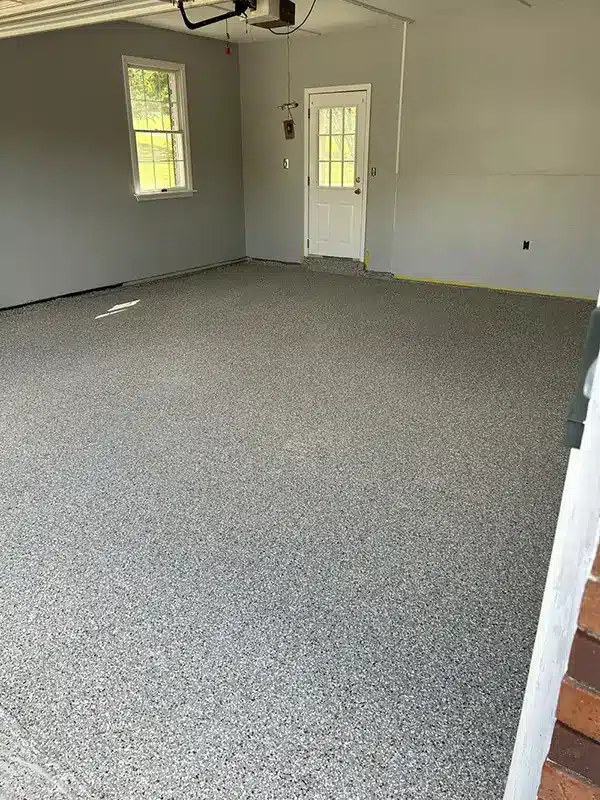 Gray epoxy garage floor with decorative flake finish in a residential garage