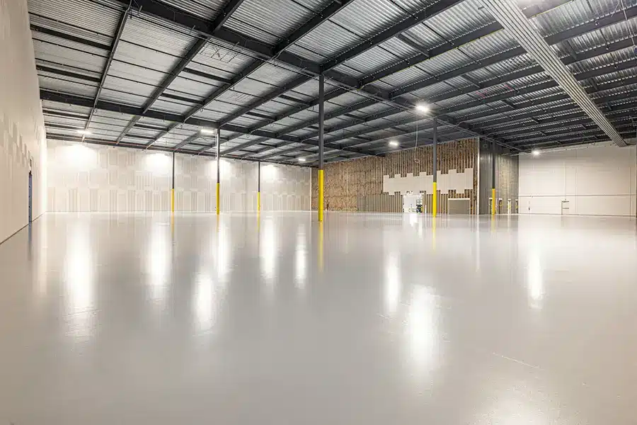 Warehouse epoxy flooring in an empty industrial warehouse with a polished concrete floor