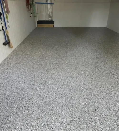 Gray epoxy garage floor with decorative flake finish in a finished residential garage