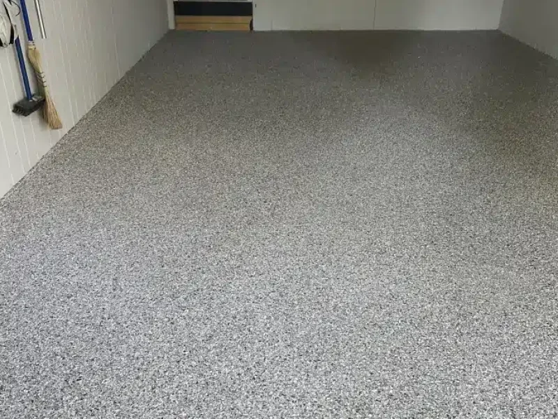 Gray epoxy garage floor with decorative flake finish in a finished residential garage
