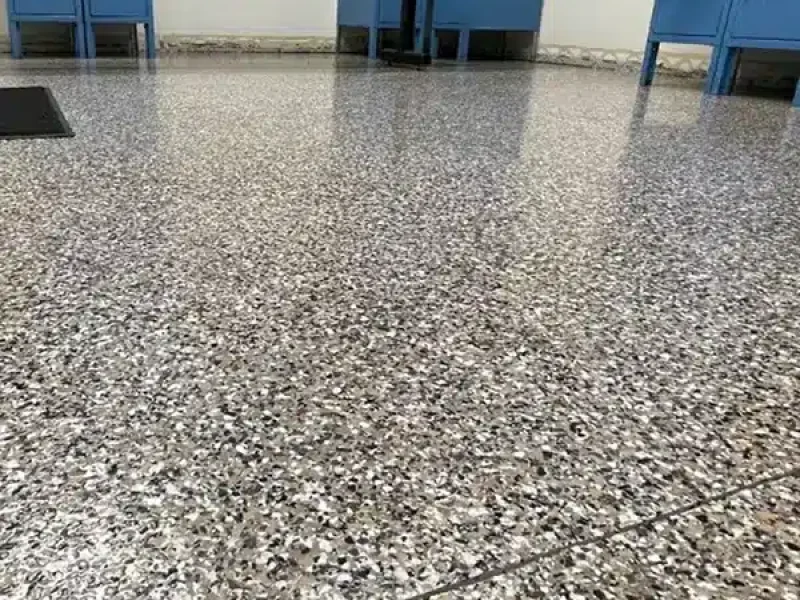 Decorative epoxy flake floor in a commercial locker room with blue lockers