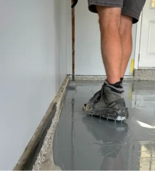 Installer walking on freshly applied gray epoxy garage floor coating