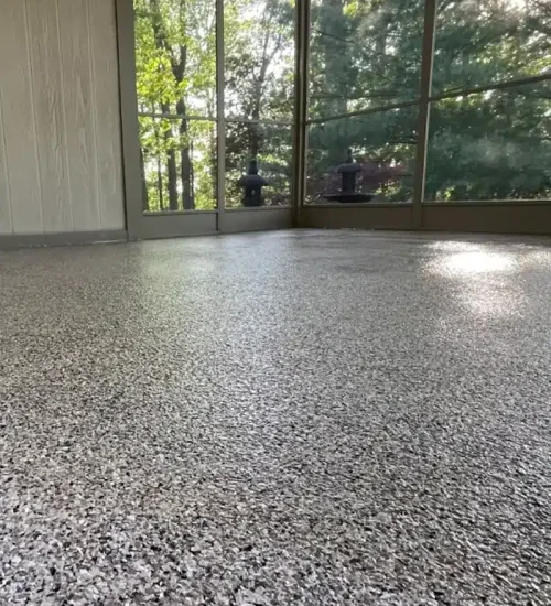 Decorative gray epoxy flake floor in a screened porch or sunroom