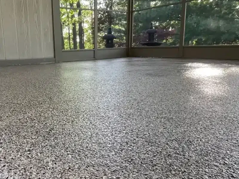 Decorative gray epoxy flake floor in a screened porch or sunroom