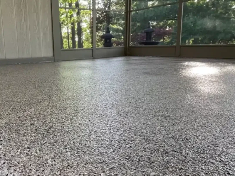 Decorative gray epoxy flake floor in a screened porch or sunroom