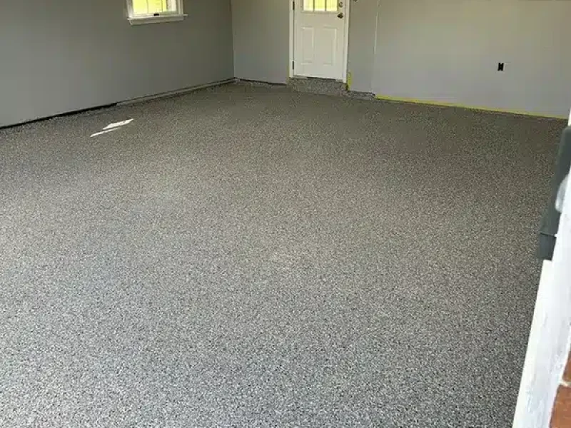Gray epoxy garage floor with decorative flake finish in a residential garage