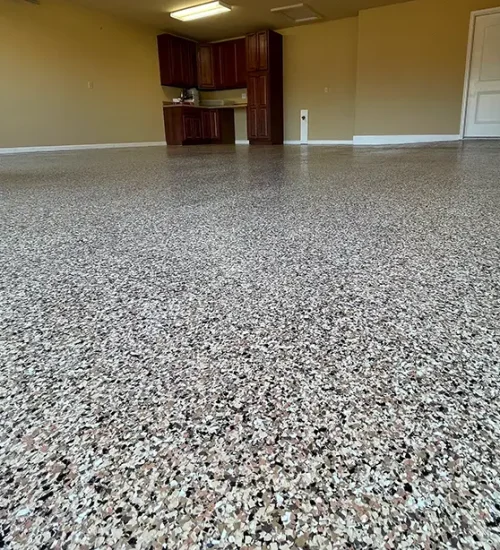 Decorative epoxy flake floor with tan, black and white chips in a finished garage