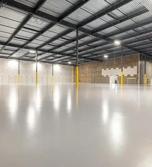 Warehouse epoxy flooring in an empty industrial warehouse with a polished concrete floor