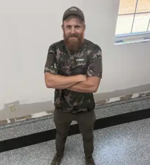 Man standing on a gray epoxy garage floor with black accent striping